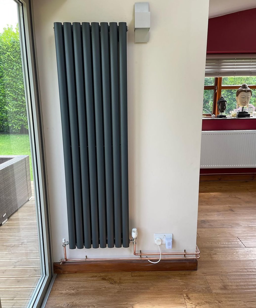 Vertical anthracite radiator installed beside patio doors