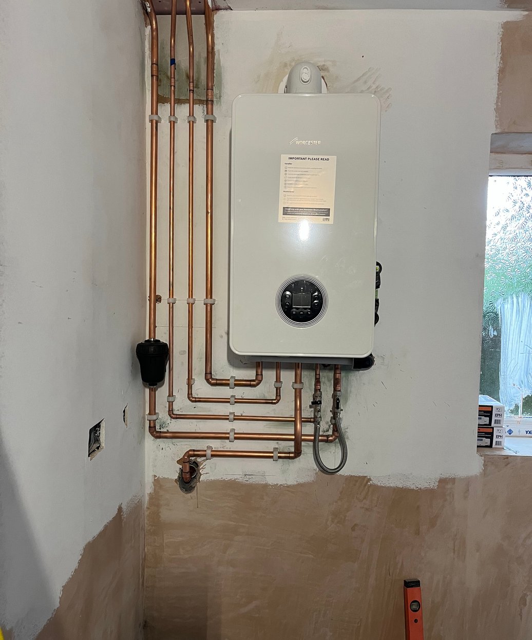 Wall-mounted boiler with neatly arranged copper pipework