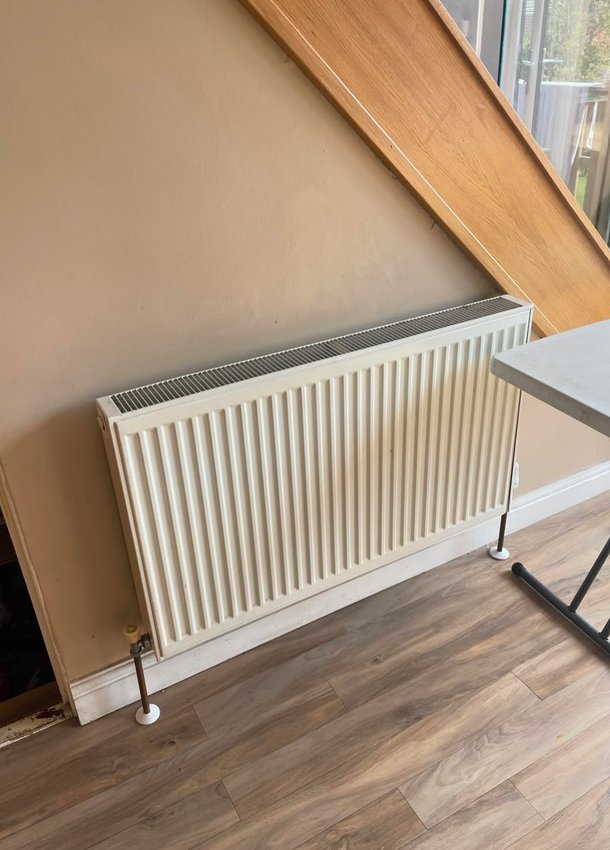 White panel radiator beneath a sloping window
