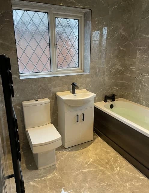 After: Modern bathroom with new white suite and sleek wall tiles