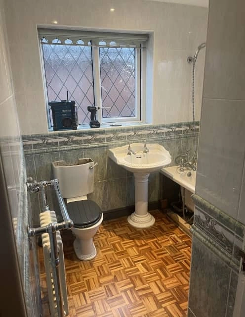 Before: Traditional bathroom with dated fixtures and tiled walls