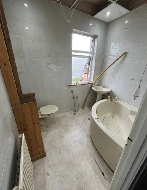 Before: Worn-out bathroom with stained tiles and dated sink