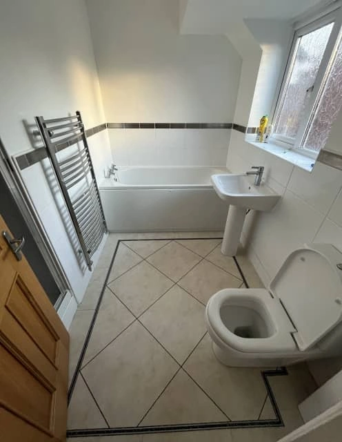 Before: Outdated bathroom with old flooring and fittings